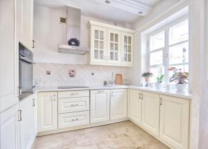 a white kitchen with white cabinets and a window at Royal Warsaw Apartment in Warsaw