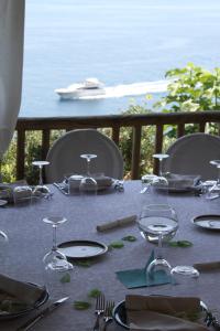 a table with plates and glasses and a view of the ocean at Hotel Costa Diva in Praiano