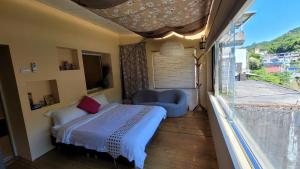 um pequeno quarto com uma cama e uma janela em Xi Yin Zhi Su em Pingxi