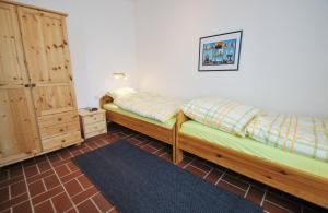 a bedroom with two beds and a dresser at An der Allee 20 C in Dahme