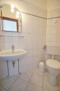 a white bathroom with a toilet and a sink at An der Allee 20 C in Dahme