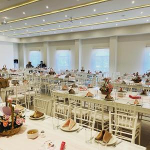 a large room with tables and chairs with people in the background at Sendero Hotel in Actopan