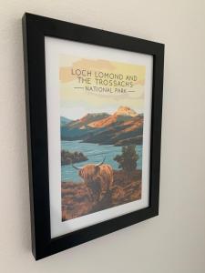 a framed poster of a mountain park with a cow at The Cochno Flat, Clydebank in Dalmuir