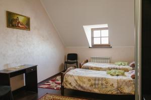 a small room with two beds and a window at Джерело in Kamianets-Podilskyi
