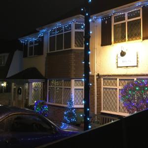 a house decorated with christmas lights and a christmas tree at Ivy House in Ickenham