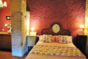 a bedroom with a bed with a red wall at Masia El Canalot - Molí Del Pont in Cornudella