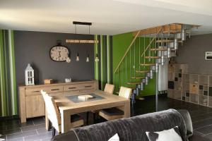 a dining room with a table and a staircase at Entre Terre et Mer in Buire-le-Sec