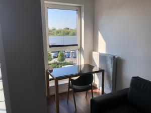 uma mesa e uma cadeira num quarto com uma janela em Apartamenty Platinex 5 em Cracóvia