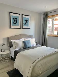 a bedroom with a large bed and two pictures on the wall at BF Suites & Apartments in Porto