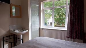 sypialnia z łóżkiem, umywalką i oknem w obiekcie Orlando's w mieście Earlham