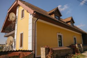 a yellow house with a brown roof at Джерело in Kamianets-Podilskyi