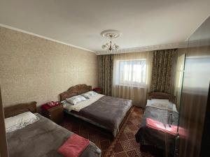 a hotel room with two beds and a window at Guest House Eles in Karakol