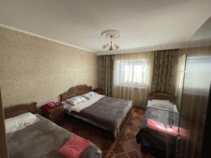 um quarto de hotel com duas camas e uma janela em Guest House Eles em Karakol