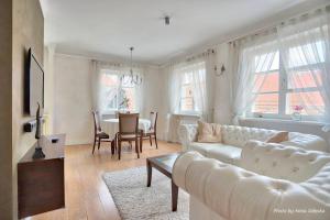 ein Wohnzimmer mit einem weißen Sofa und einem Tisch in der Unterkunft Royal Warsaw Apartment in Warschau