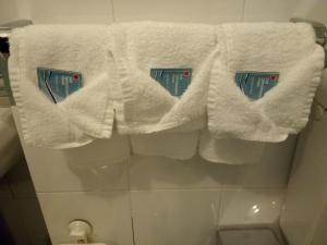 a bunch of white towels hanging above a toilet at Hotel Tirreno in Genoa