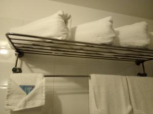 a towel rack with towels and a mirror in a bathroom at Hotel Tirreno in Genoa