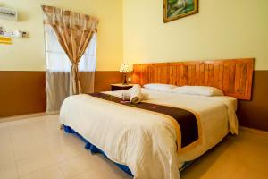 Un dormitorio con una cama grande y una ventana en NR Langkawi Motel en Pantai Cenang
