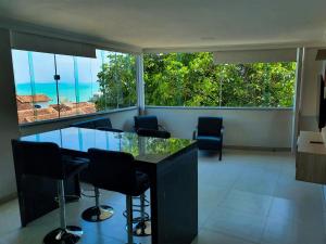 a dining room with a glass table and chairs at Apartamento Novo em Iriri - Vista para o Mar in Iriri