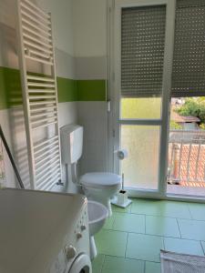 bagno con servizi igienici, vasca e finestre di Appartamento Libeccio a Finale Ligure
