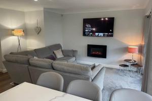 a living room with a couch and a tv at 2 bedroom 2 bathroom luxury apartment 1 minute from Lake pet friendly free parking in Winster