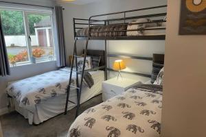 a bedroom with two bunk beds and a window at 2 bedroom 2 bathroom luxury apartment 1 minute from Lake pet friendly free parking - FREE off-site Health Club access with Pool, Sauna, Steam Room & Gym Short 10 Minute Drive Away in Winster