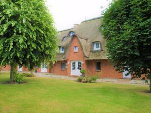 a large red brick house with a roof at Deichblick - a26817 in Büsumer Deichhausen