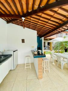 an outdoor kitchen and dining area with a table and chairs at Casa de praia aconchegante em Sonho Verde in Paripueira