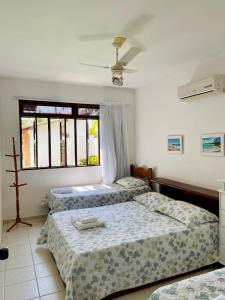 a bedroom with two beds and a window at Casa de praia aconchegante em Sonho Verde in Paripueira