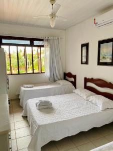 a bedroom with two beds and a window at Casa de praia aconchegante em Sonho Verde in Paripueira +43 photos