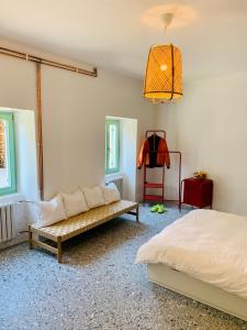 ein Schlafzimmer mit einem Bett, einer Bank und einer Lampe in der Unterkunft Samson and the Lilo in Vipava