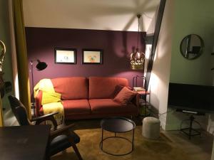 uma sala de estar com um sofá vermelho e uma televisão em B&B Logeren bij de burgemeester em Stad aan ʼt Haringvliet