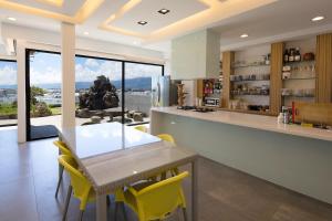 a kitchen with a dining table and yellow chairs at 松柏文旅Cypress Inn in Taitung City