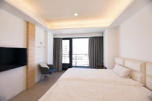 Habitación de hotel con cama grande y TV en 松柏文旅Cypress Inn en Taitung