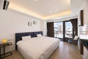 a bedroom with a large bed and a balcony at 松柏文旅Cypress Inn in Taitung City