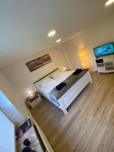 een slaapkamer met een bed en een flatscreen-tv bij Schöne Wohnung mit Garten beim Outletcenter 5 km in Boostedt