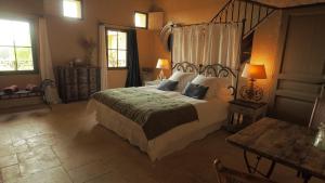 una camera con un grande letto e un tavolo di Le Clos Saint Saourde a Beaumes-de-Venise