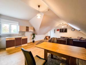 a living room with a dining table and a kitchen at XXL Rooms Osijek in Osijek