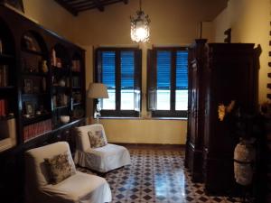 sala de estar con 2 sillas y lámpara de araña en La Casa Del Duca en Porticalazzo