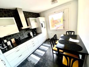 a kitchen with a table and a black and white at DP Apartments Vaasa IV in Vaasa