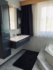 a bathroom with a sink and a mirror at Appartement Lilly in Lehn