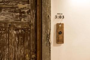un mur avec une porte en bois munie d'un thermomètre. dans l'établissement Velawarin Hotel, à Ubon Ratchathani