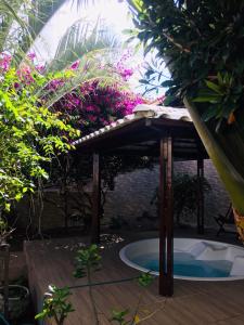 a wooden deck with a plunge pool in a garden at Pousada Mirante do Cunhaú in Barra do Cunhau