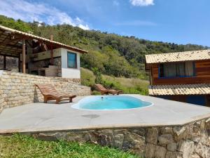 a patio with a swimming pool in front of a house at Chale com agua de nascente e com vista panoramica in Lumiar