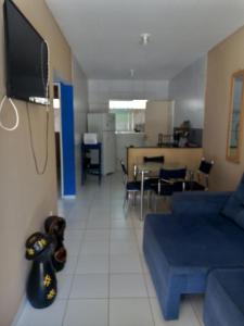 ein Wohnzimmer mit einem blauen Sofa und einem Fernseher in der Unterkunft Casa de praia para temporada in Paulista