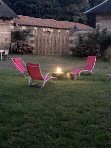un gruppo di sedie seduti in un cortile con buca per il fuoco di Gîte Aux chênes a La Viardière