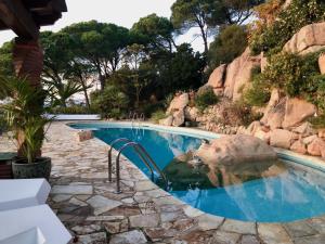 a swimming pool with a rock in the water at Villa Panorama 360 in Lloret de Mar