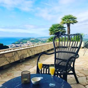 a table with two glasses of orange juice on a balcony at Villa Panorama 360 in Lloret de Mar