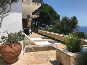 a patio with a white bench and a vase at Villa Panorama 360 in Lloret de Mar