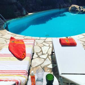 una piscina con una mesa blanca y toallas rojas. en Villa Panorama 360, en Lloret de Mar