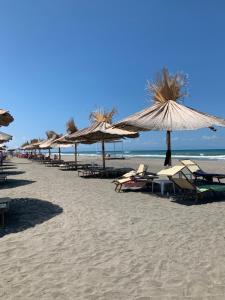 rząd parasoli i leżaków na plaży w obiekcie Sunrise w mieście Margherita di Savoia